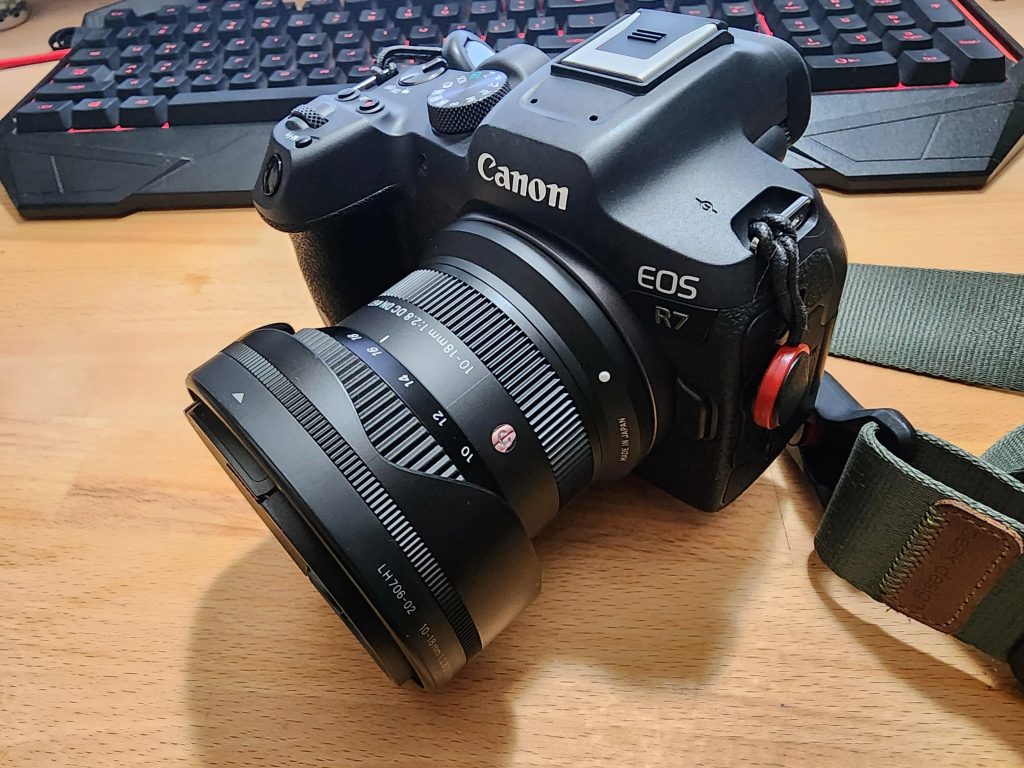 Нативний APS-C об'єктив Sigma 10-18mm F2.8 DC DN встановлений безпосередньо на байонет Canon EOS R7 без жодного перехідника, поруч на столі лежить ігрова клавіатура.
